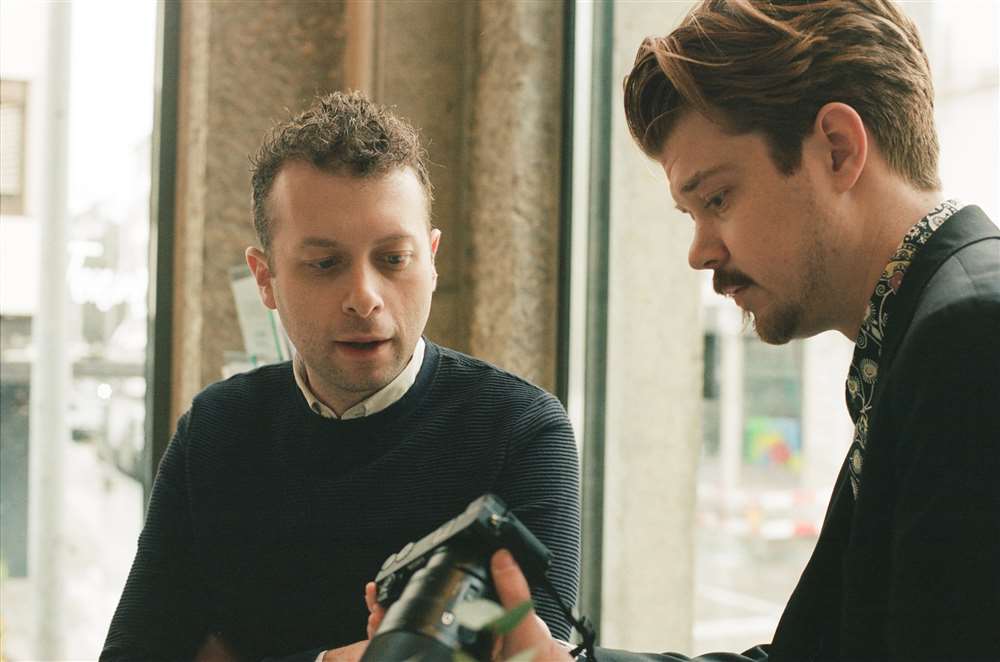 Danny 和 Logan 在 Fp Journ 精品店里看着相机。