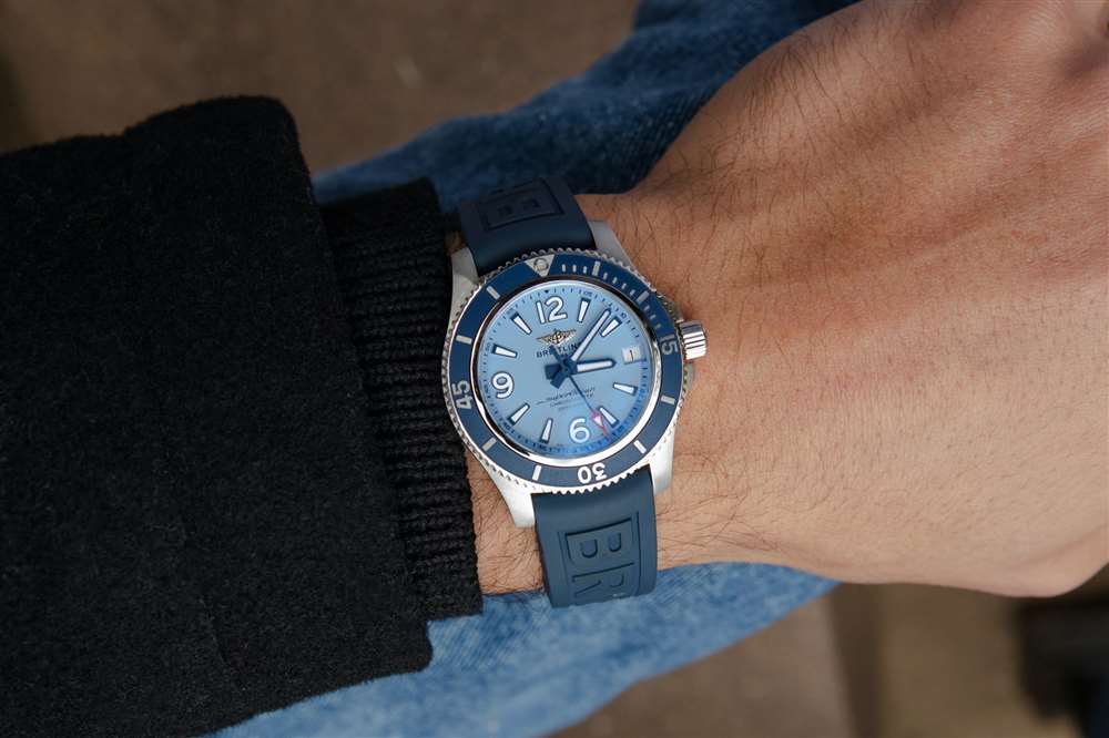 一位男士佩戴浅蓝色表盘的百年灵超级海洋腕表。