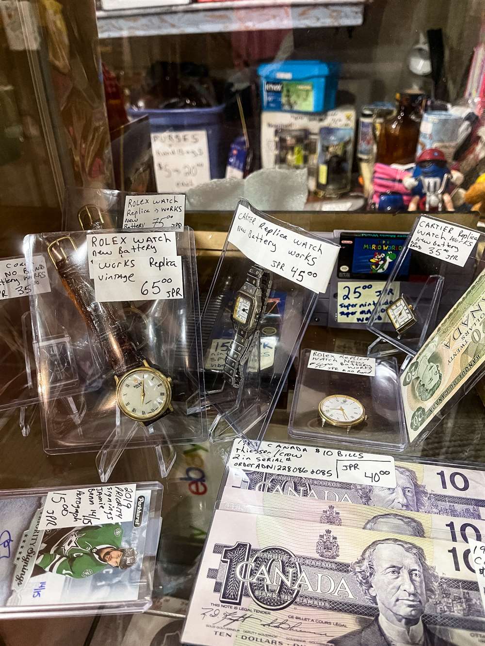 一个柜子，里面有几块古董手表、曲棍球卡和货币。