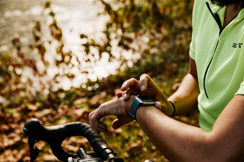 骑自行车的人正在检查他们的 Apple Watch