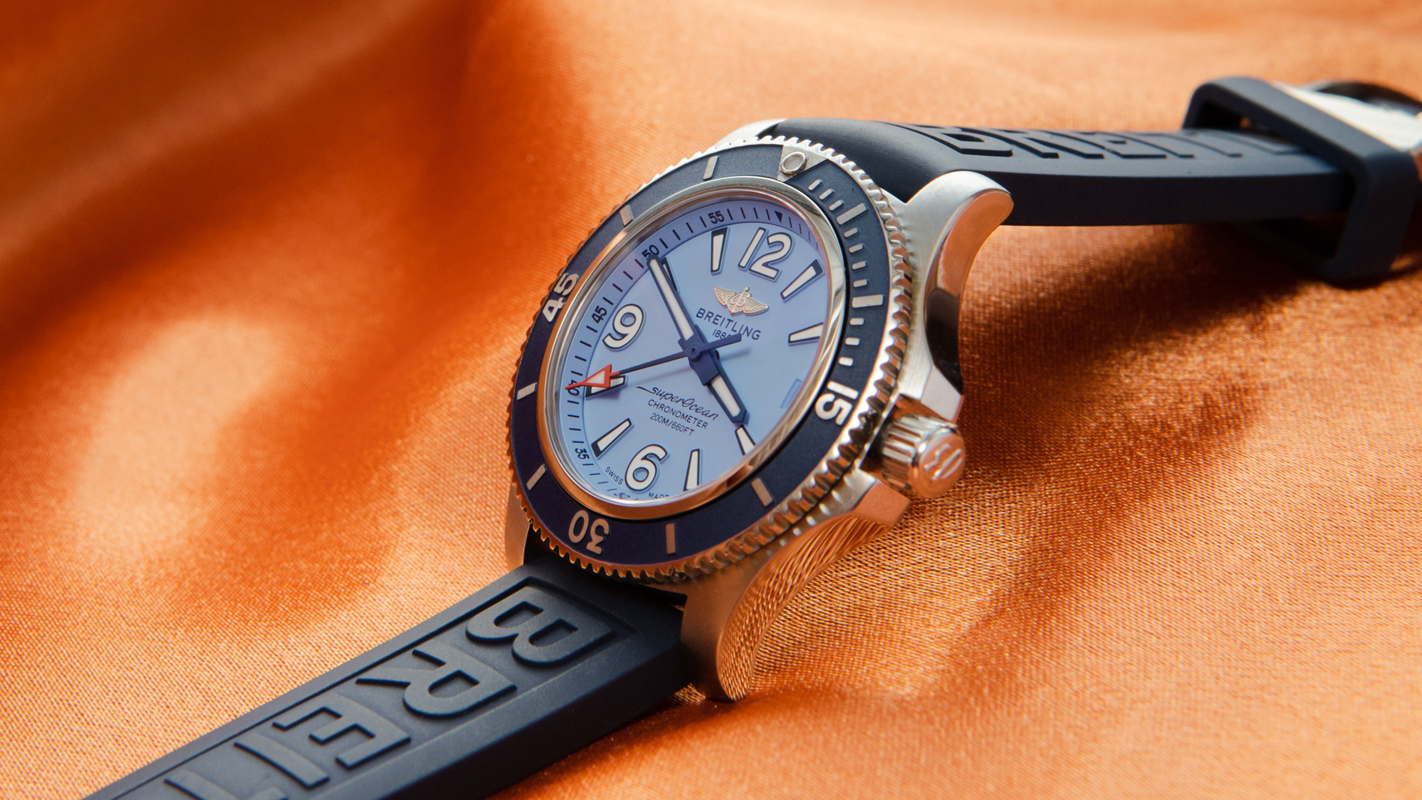 橙色背景中的蓝色百年灵手表