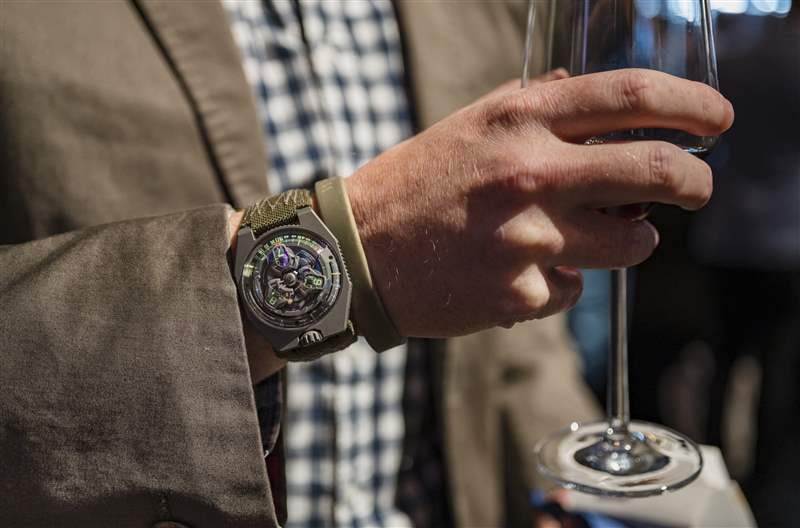 一位拿着香槟酒杯的男士手腕上的 Urwerk 手表。